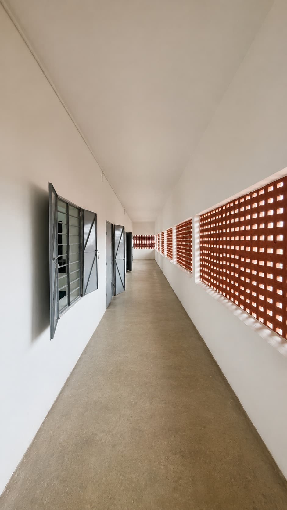 Corridor — perforated brick jali screen along a washroom wing