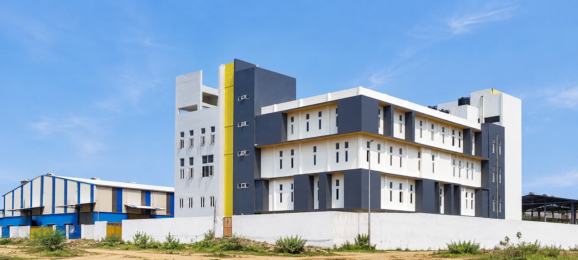 Exterior — the completed building beside the adjoining industrial shed
